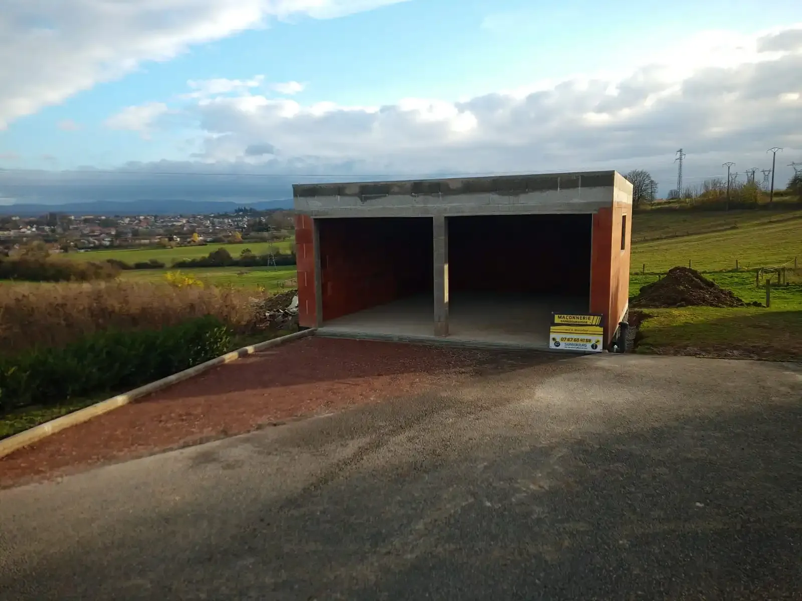 Garage double en briques avec dalle béton, vue sur la campagne